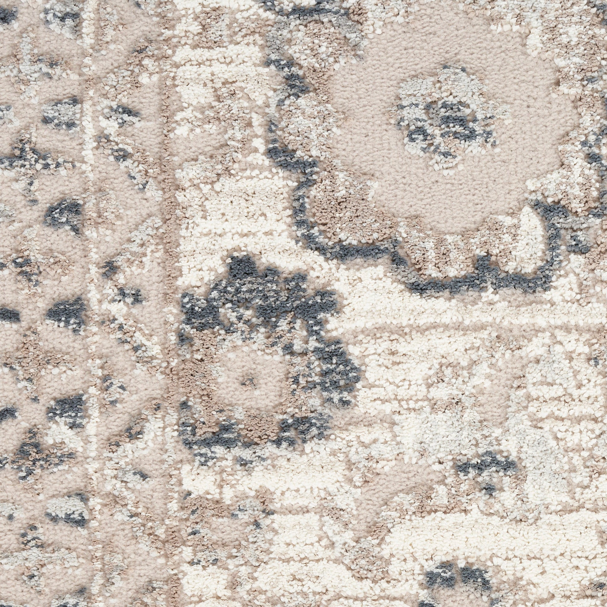 Rectangular beige area rug with blue-gray floral medallion pattern; distressed, plush pile for living room decor.