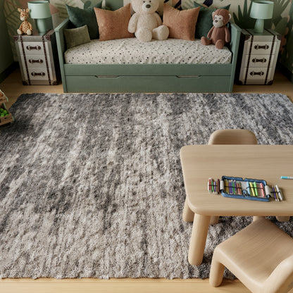 Soft gray shag rug in a kids' room with light wood table and chair, pastel-green sofa bed, polka-dot bedding, and plush bears.