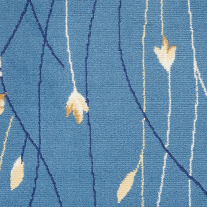 Blue rug featuring navy vine lines and pale cream leaf motifs in a modern botanical pattern.