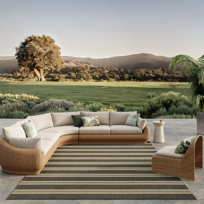 Striped outdoor rug (10' x 14') on a patio with curved wicker sectional and beige cushions.