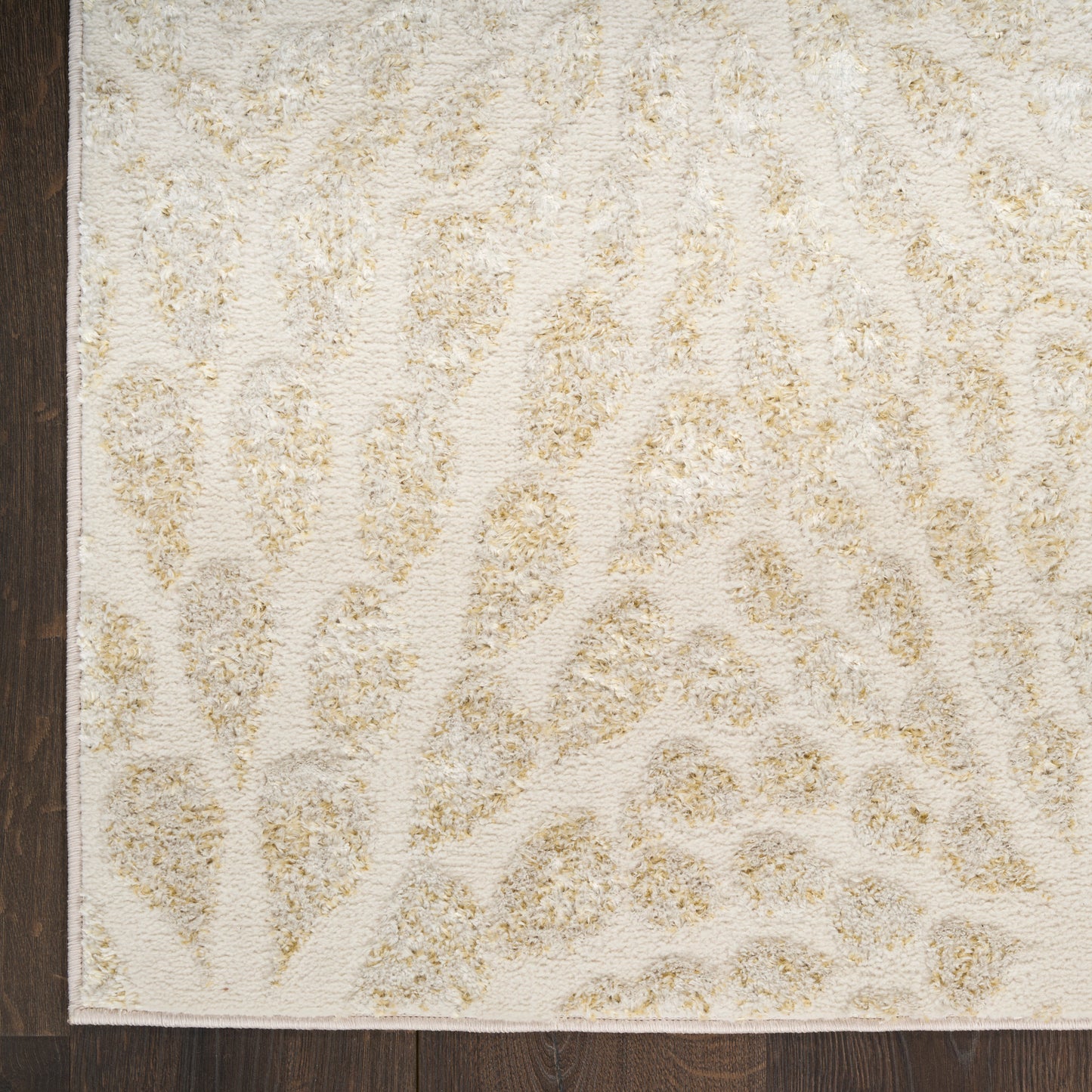 Beige rectangular area rug with cream background and tan leopard-print pattern on dark wood floor.