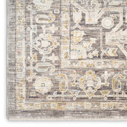 Traditional area rug with ornate floral and geometric borders in gray, ivory, pale blue and yellow, distressed antique look.