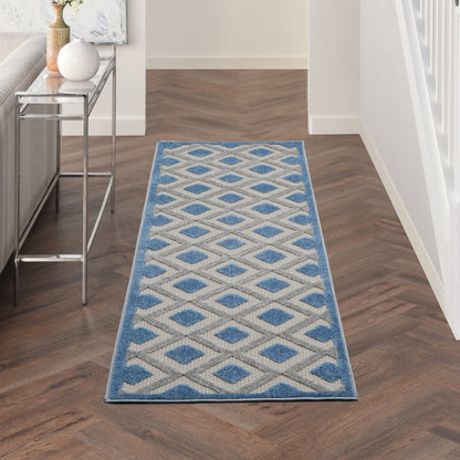 Long blue and ivory geometric diamond runner rug in a hallway with a blue border.