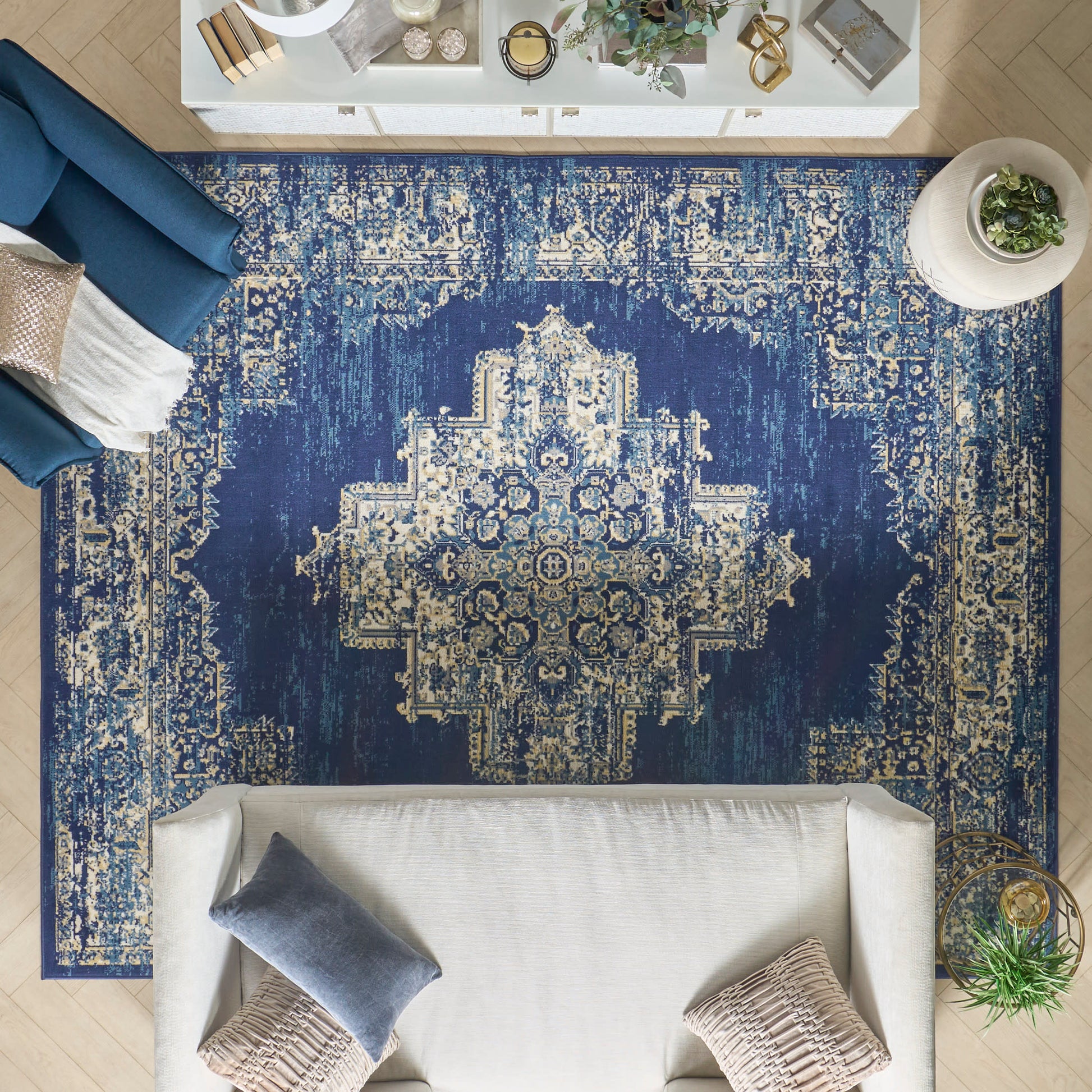 Overhead view of a navy blue distressed oriental rug with a cream central medallion in a modern living room.