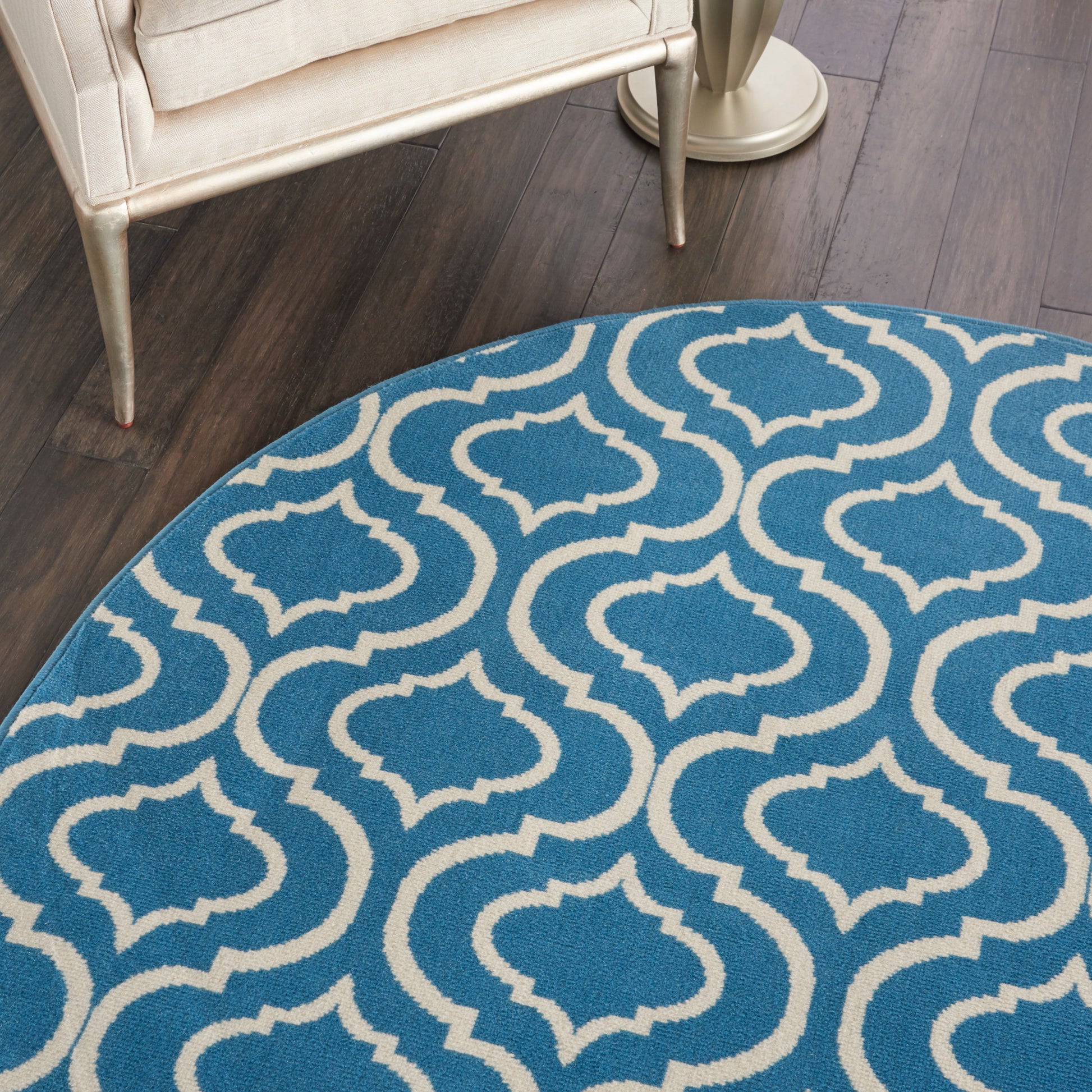 Blue-gray gradient round rug on wood floor with teal patterned border at the edge.