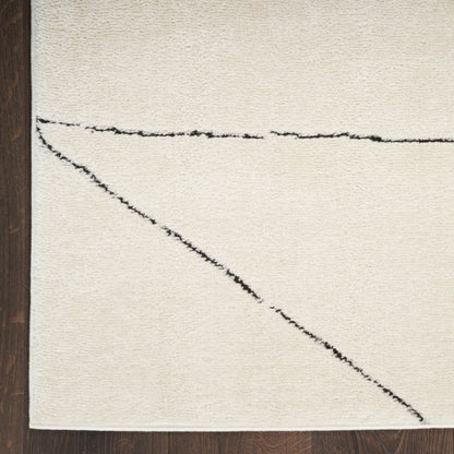 Cream rug with black horizontal and diagonal abstract lines on dark wood floor.