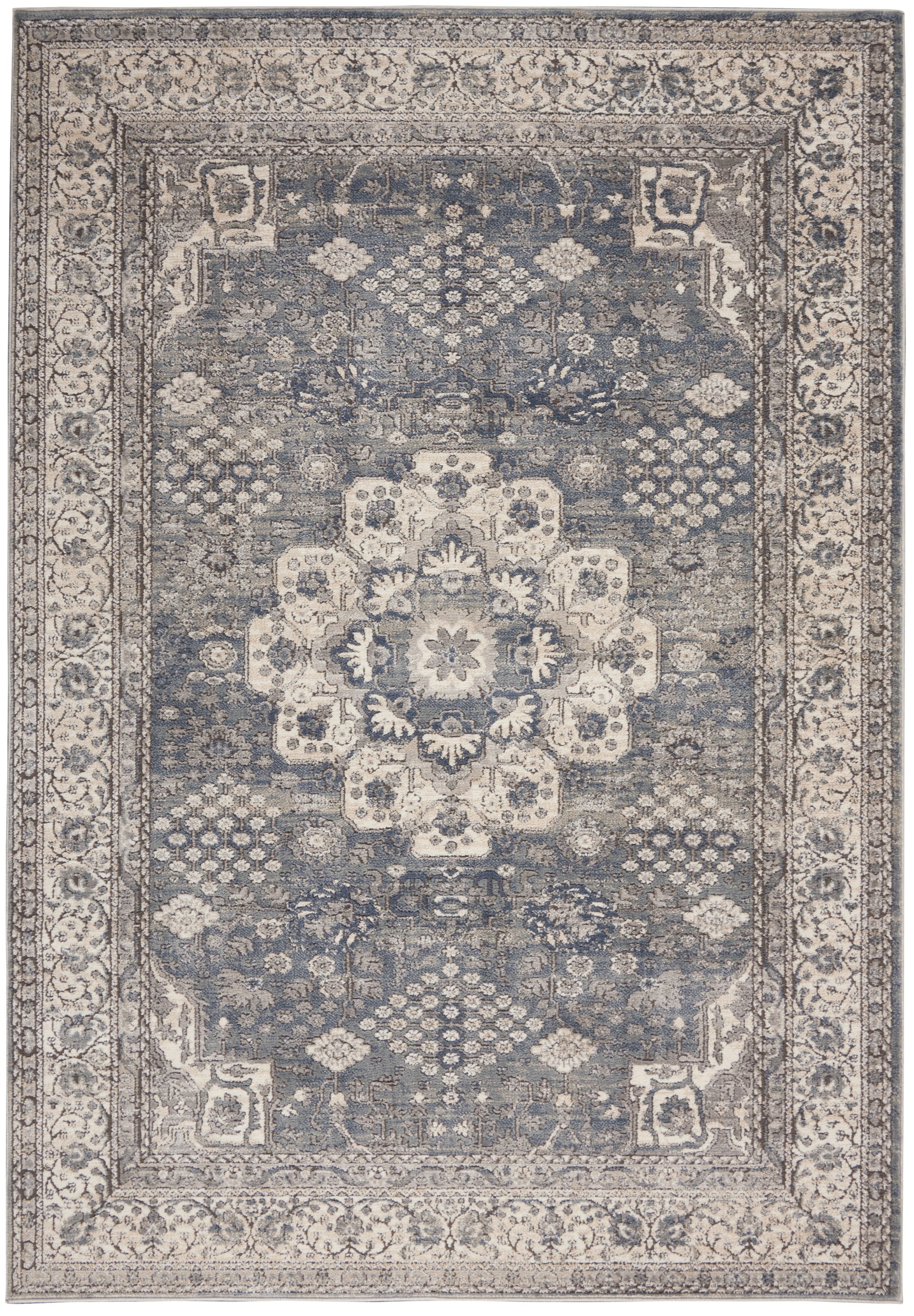 Blue-gray oriental rug with distressed ivory central medallion, ornate floral border and geometric corner motifs.