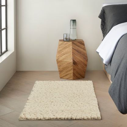 Geometric rug on a light wood floor in cream and gray tones.