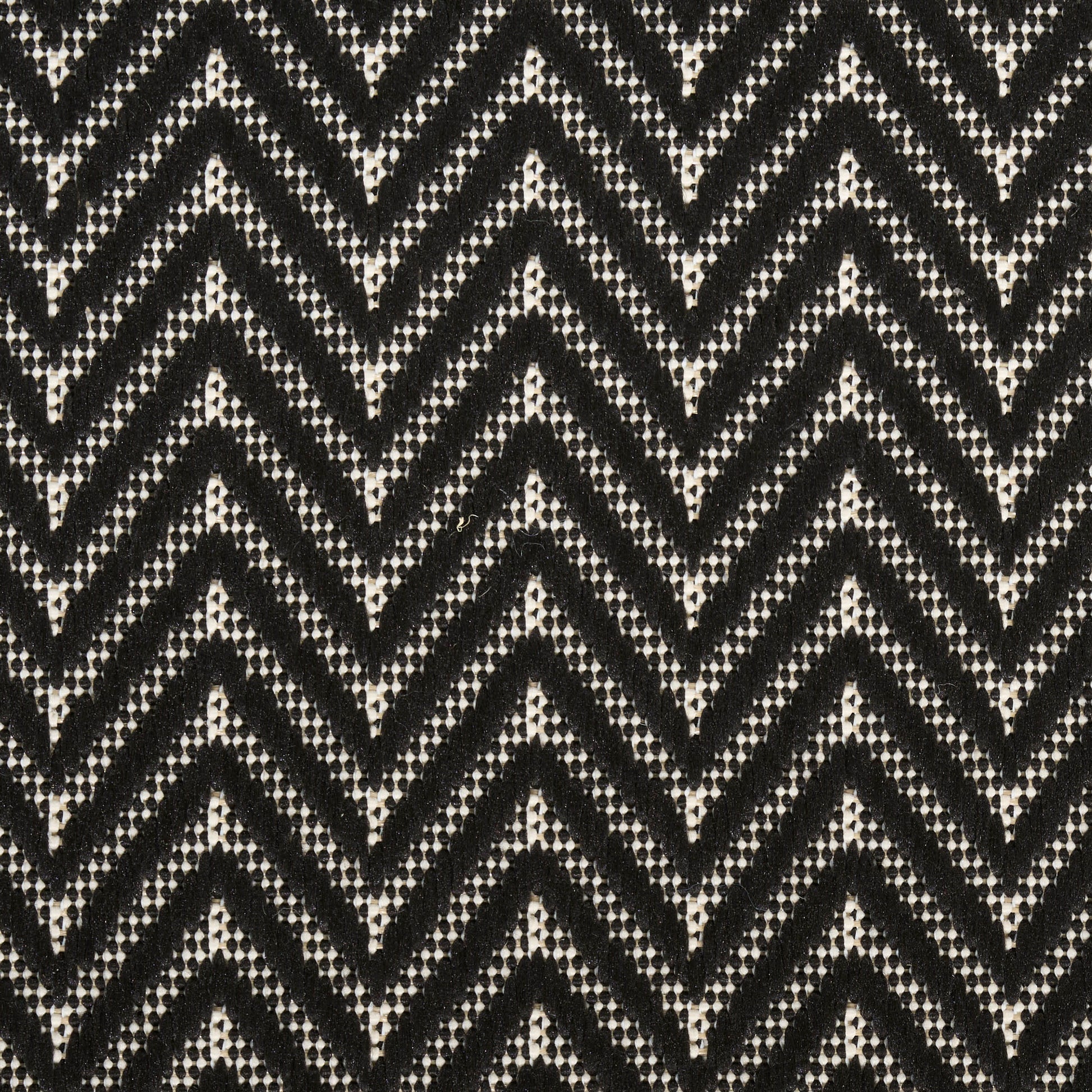 Black and white chevron knit fabric with dotted weave pattern.