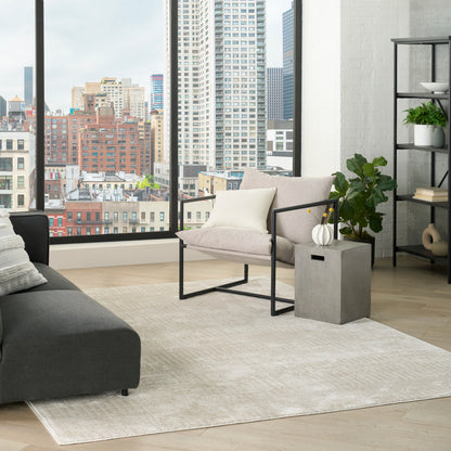 Modern city-view living room with beige fabric armchair on a black metal frame, dark gray sofa, light rug, concrete table.