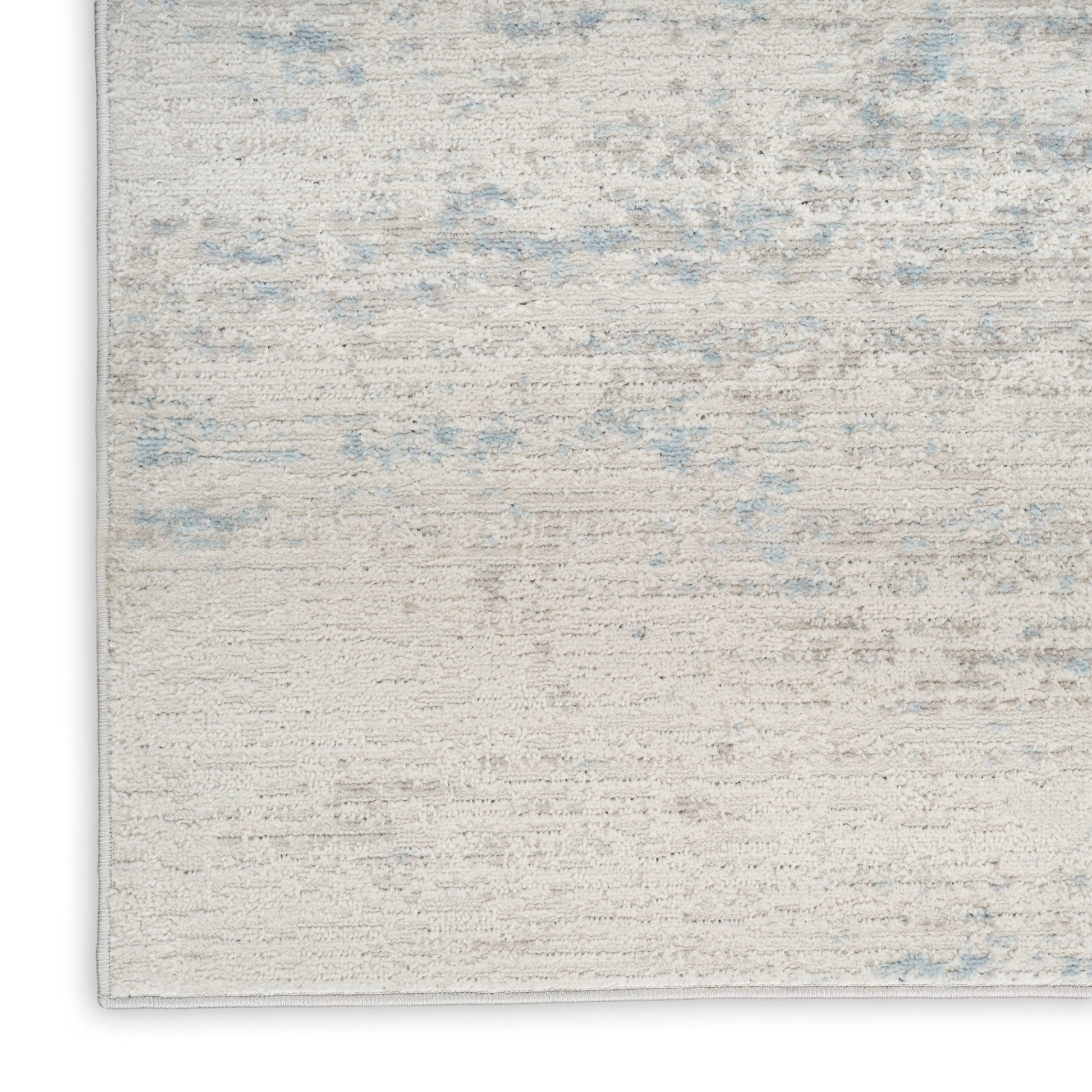 Rectangular beige area rug with soft plush pile and pale blue speckles for a subtle modern look.
