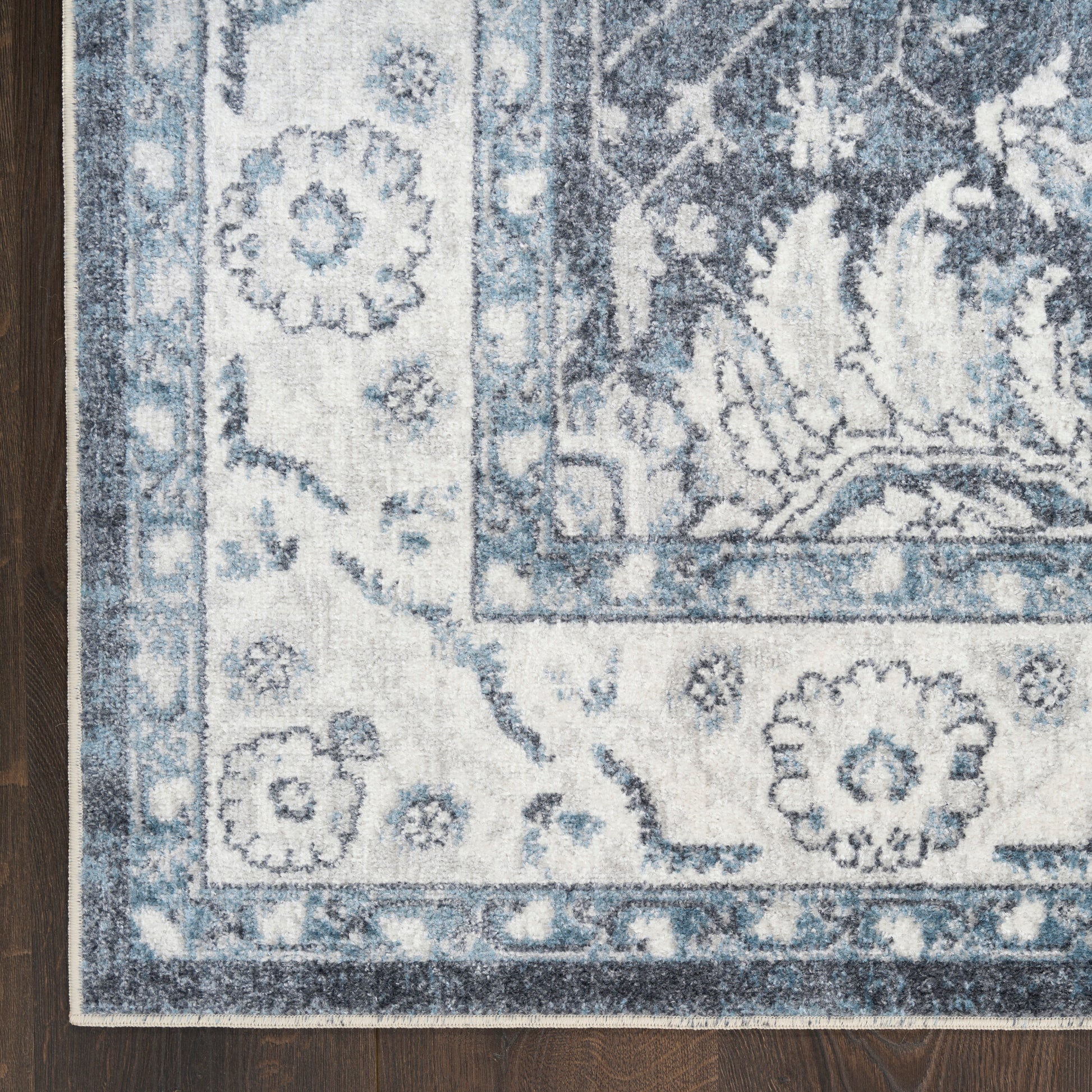 Blue and ivory woven 6 ft runner rug with floral damask border on dark wood floor.