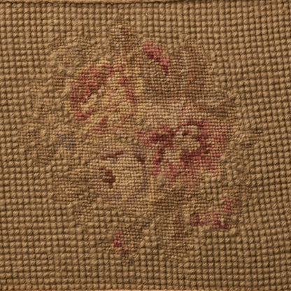 Coarse brown burlap fabric featuring a faded vintage floral pattern in red and beige.