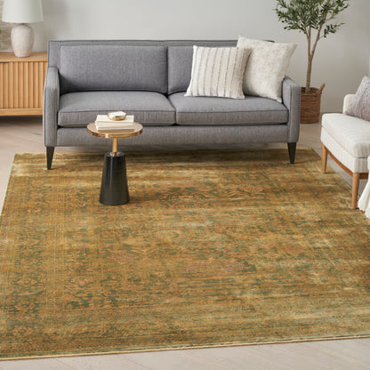 Gray vintage rug with olive-green tones in a cozy living room; round wood-and-black side table with books nearby.