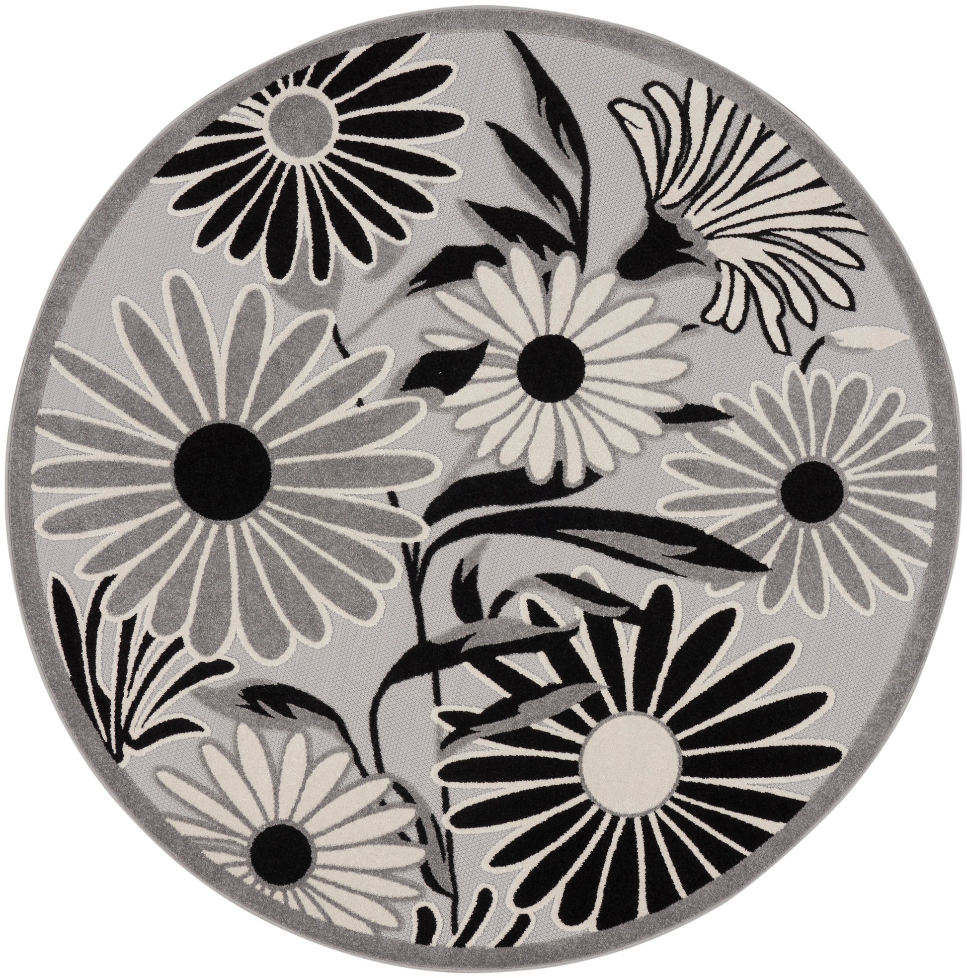 Round gray rug with bold black-and-white daisies and leaf motifs.