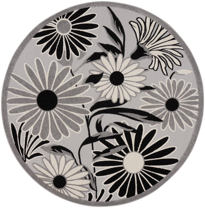 Round gray rug with bold black-and-white daisies and leaf motifs.