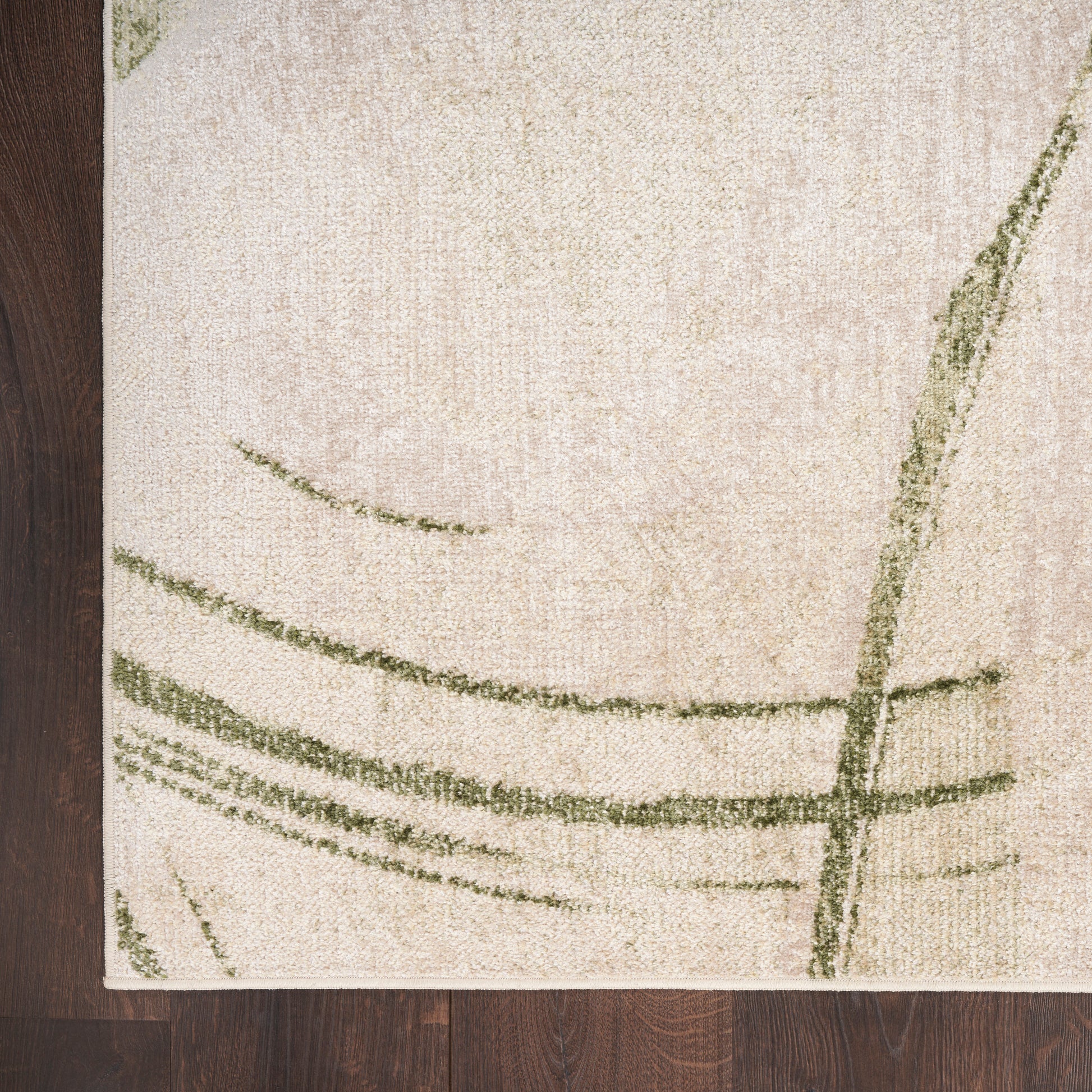 Beige rectangular rug with abstract green curved lines on a dark wooden floor.
