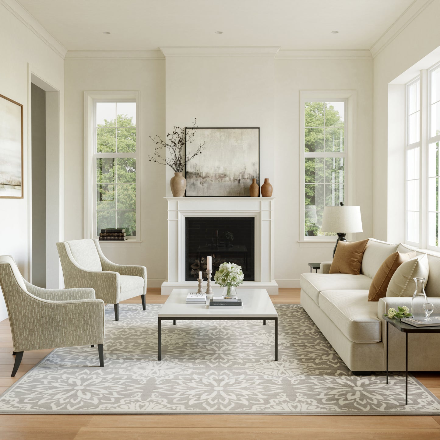 Cream sofa, pale patterned chairs, white coffee table, light floral rug, fireplace with art and vases in a living room.
