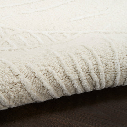 Cream ivory textured area rug with plush loop pile and ribbed edge on dark wood floor.