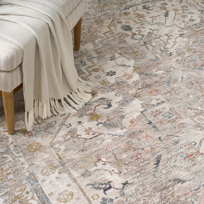Soft vintage-style area rug in muted grays, blues & taupe with fringe.
