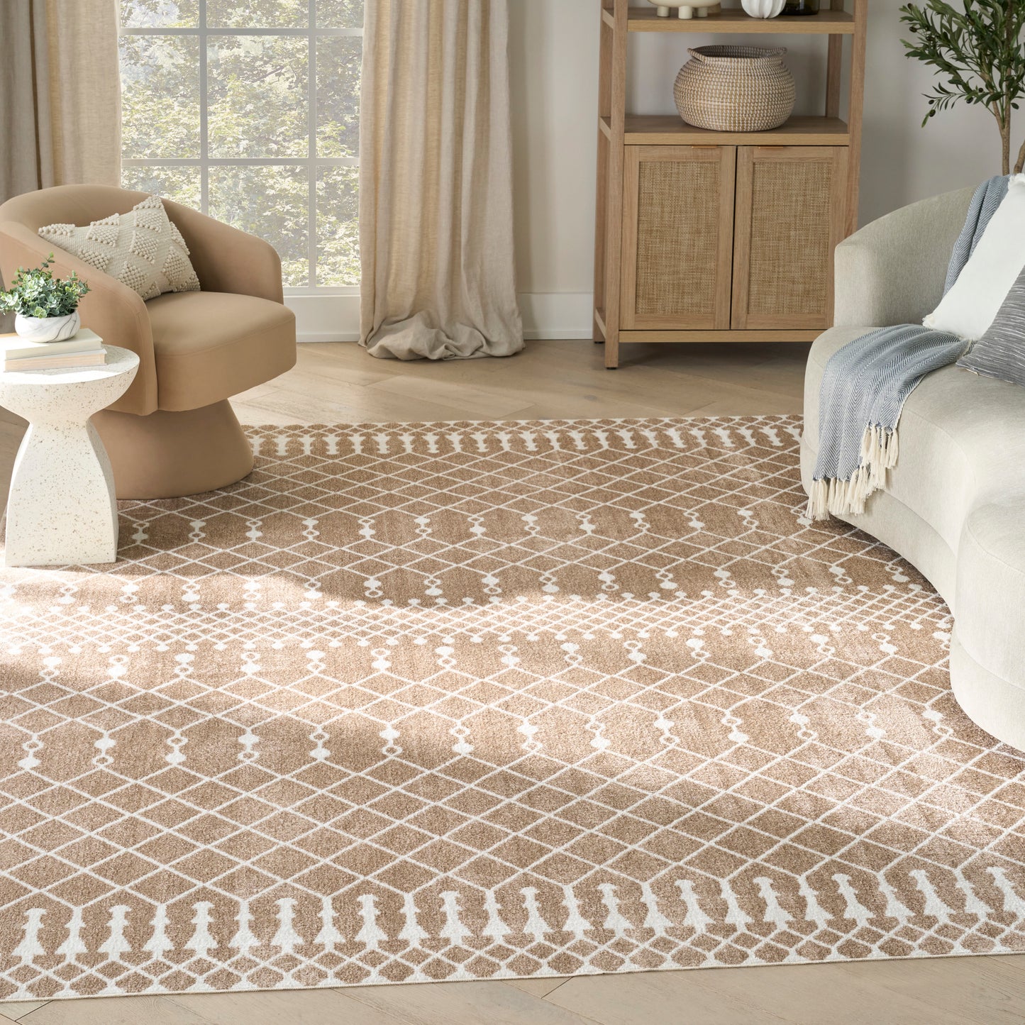 Neutral living room with tan accent chair, cream sofa, woven cabinet, potted plant, and beige lattice-pattern rug.