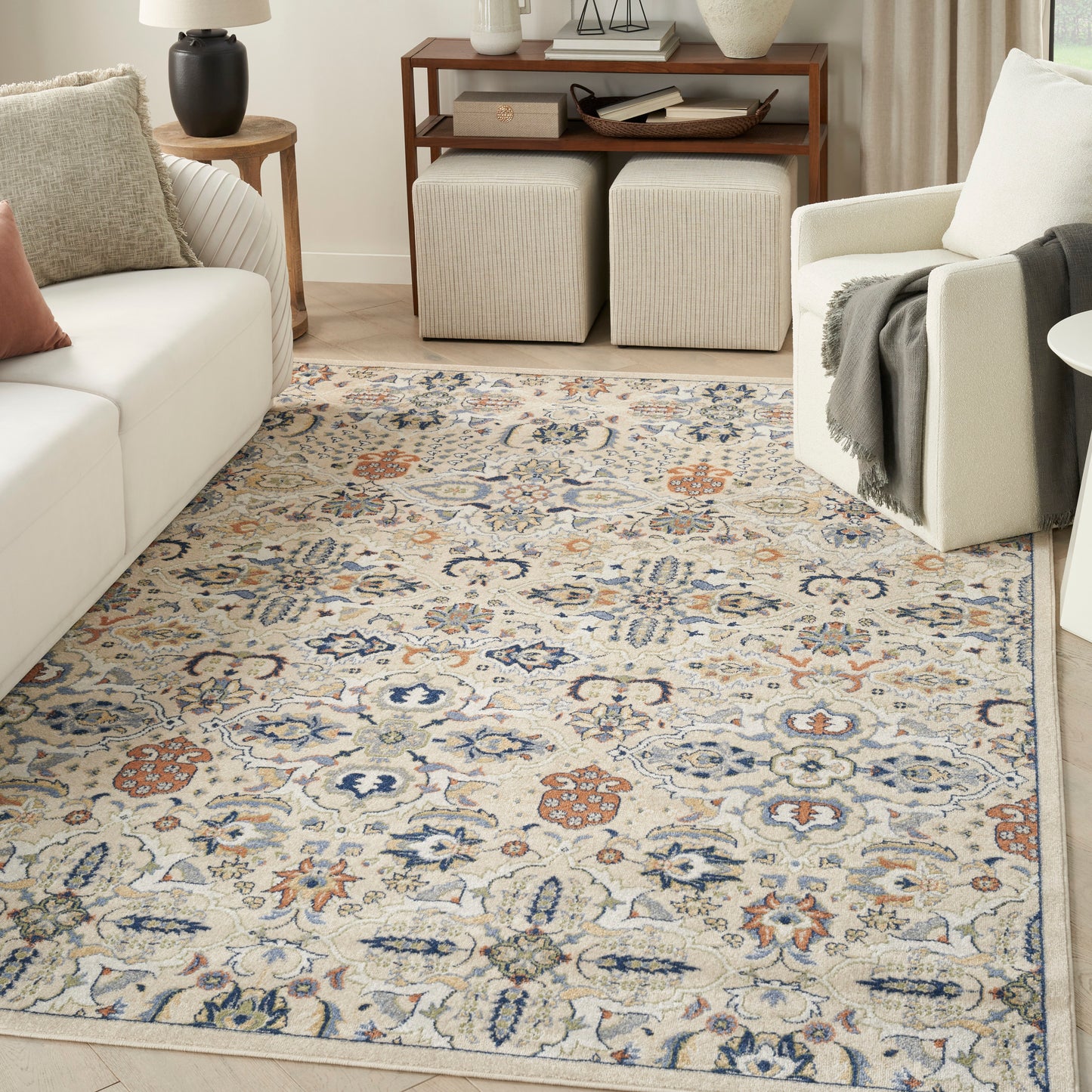 Rectangular beige area rug with blue, rust and cream floral motifs in a Persian-inspired pattern for a cozy living room.