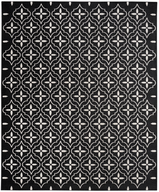 Black rug featuring a white repeating quatrefoil lattice pattern for bold geometric decor.
