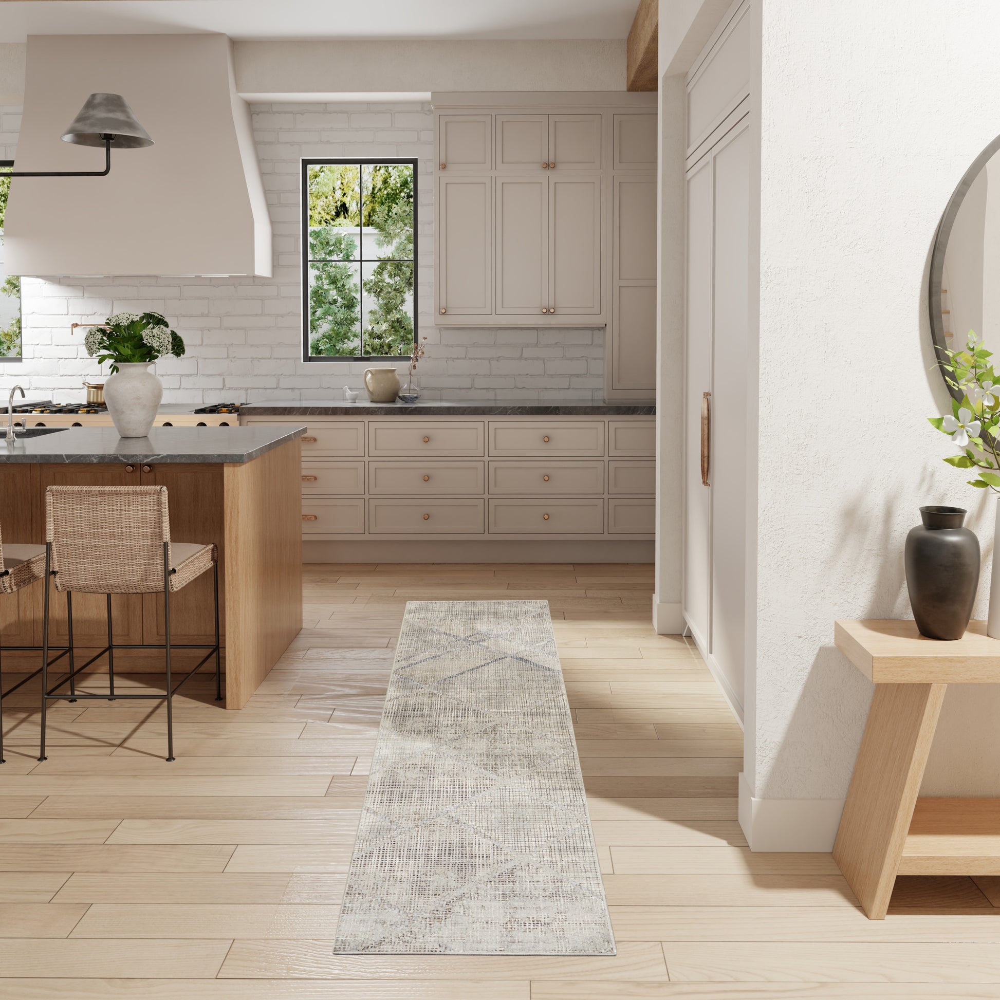 Bright modern farmhouse kitchen with white cabinets, light wood floors, a gray runner, & an island with stools.