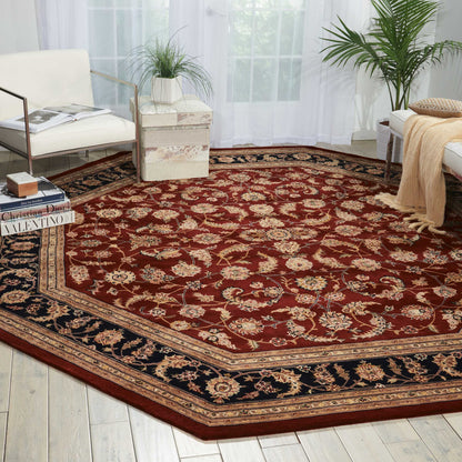Large red Persian-style area rug with cream floral motifs and a dark navy border in a bright living room.