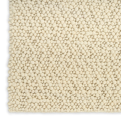 Cream boucle textured rug close-up with dense rounded tuft loops, plush cozy look.