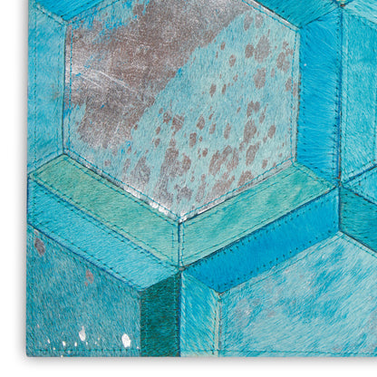 Close-up of turquoise hexagonal quilted art with stitched seams, teal and blue panels, speckled brushed texture.