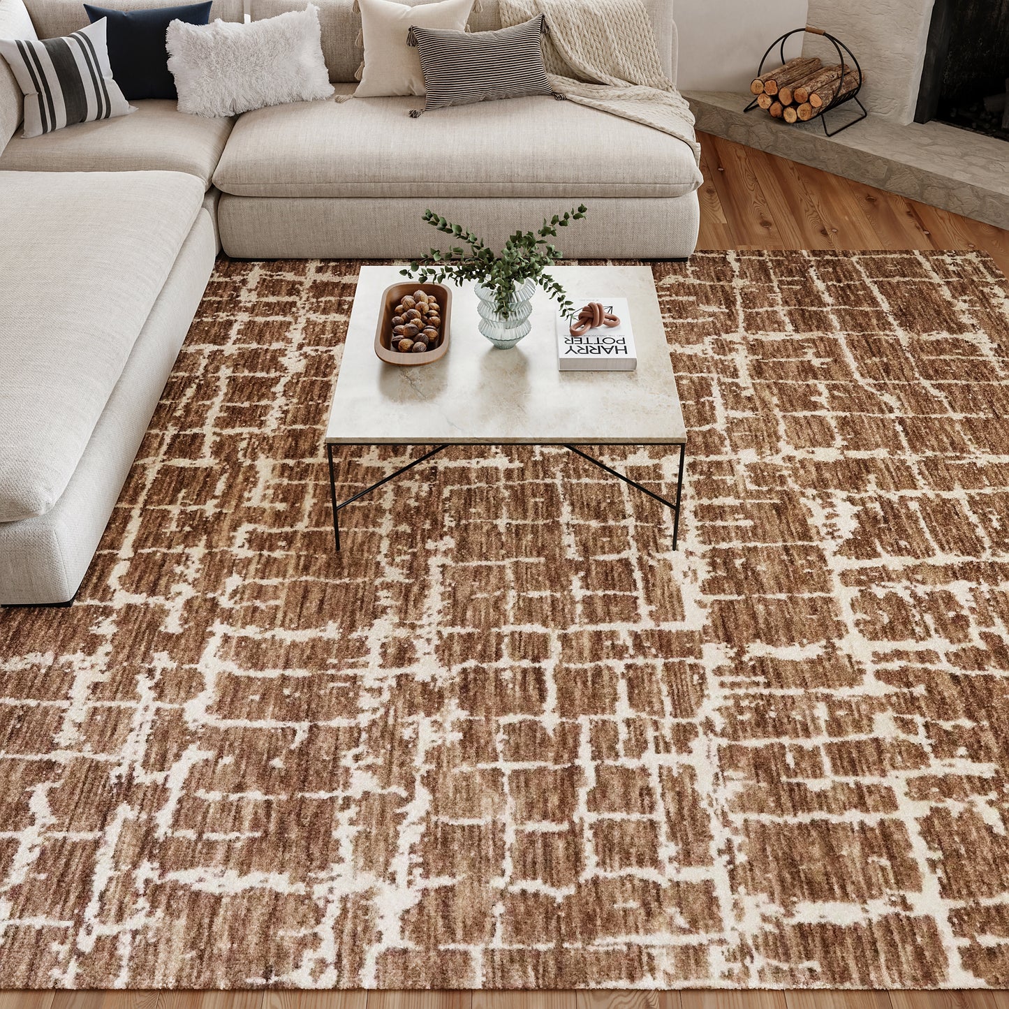 Modern neutral living room with brown & white geometric rug, beige sectional & marble-top coffee table.