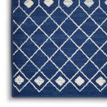 Navy blue woven rug with white diamond lattice pattern and subtle texture; edge visible.
