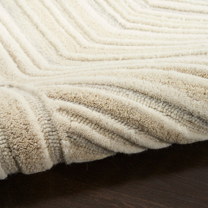 Cream plush throw blanket with ribbed chevron pattern, draped on dark wood surface.