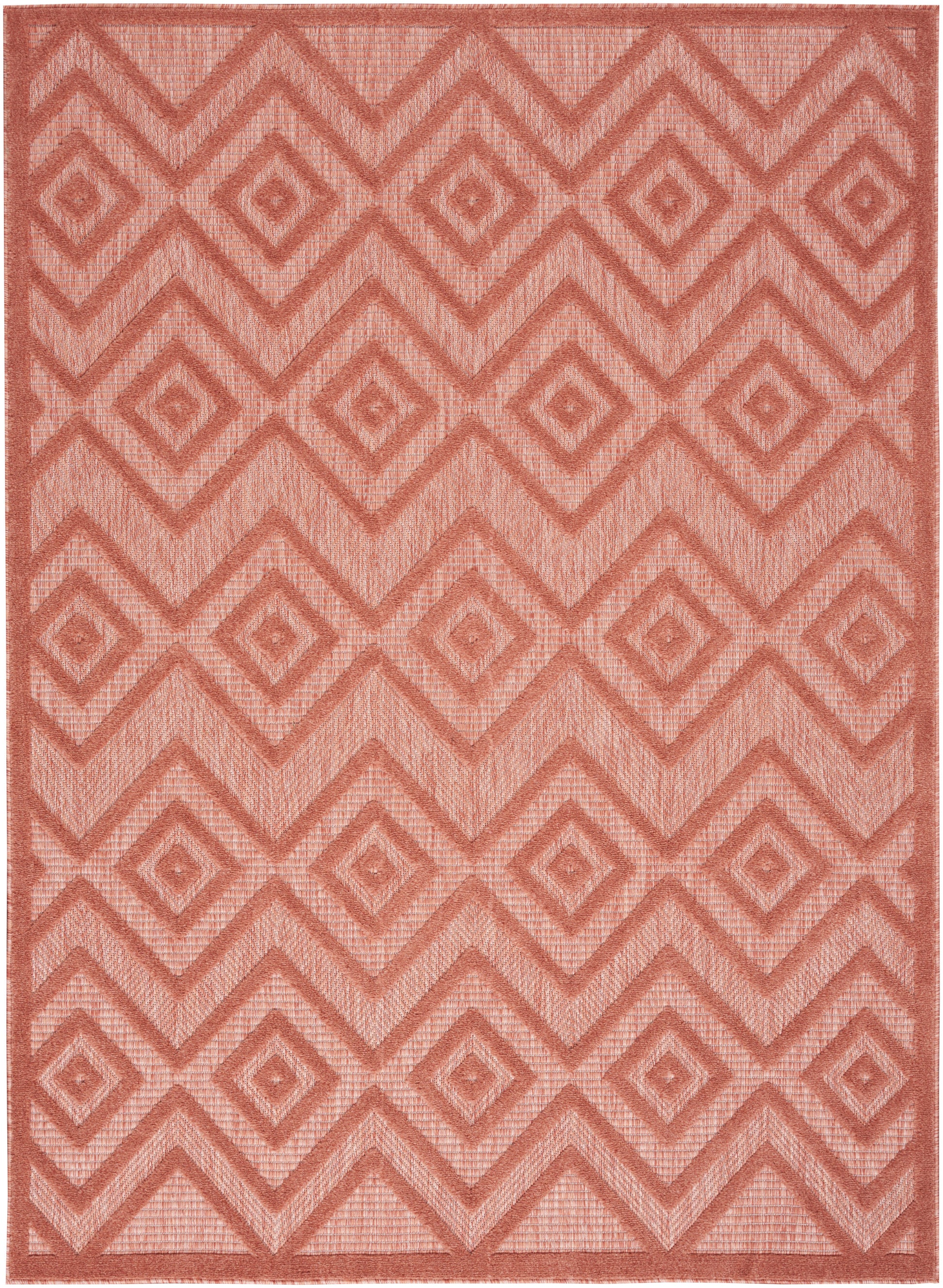 Coral pink geometric area rug with nested diamonds and chevron pattern in a woven texture.