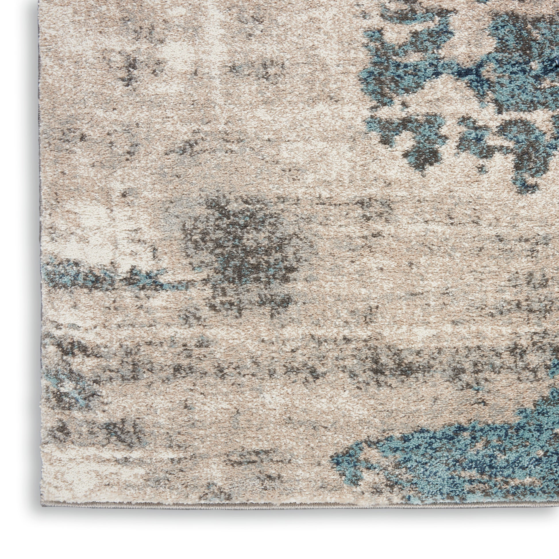 Beige distressed area rug with blue & gray abstract floral pattern & vintage texture.