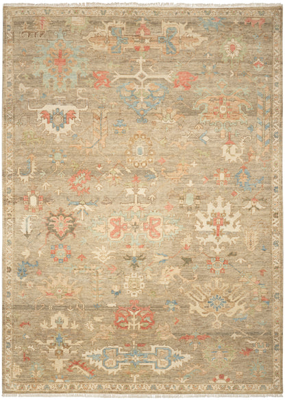 Beige distressed oriental rug with pastel blue, pink and gold geometric medallions; fringed edges.