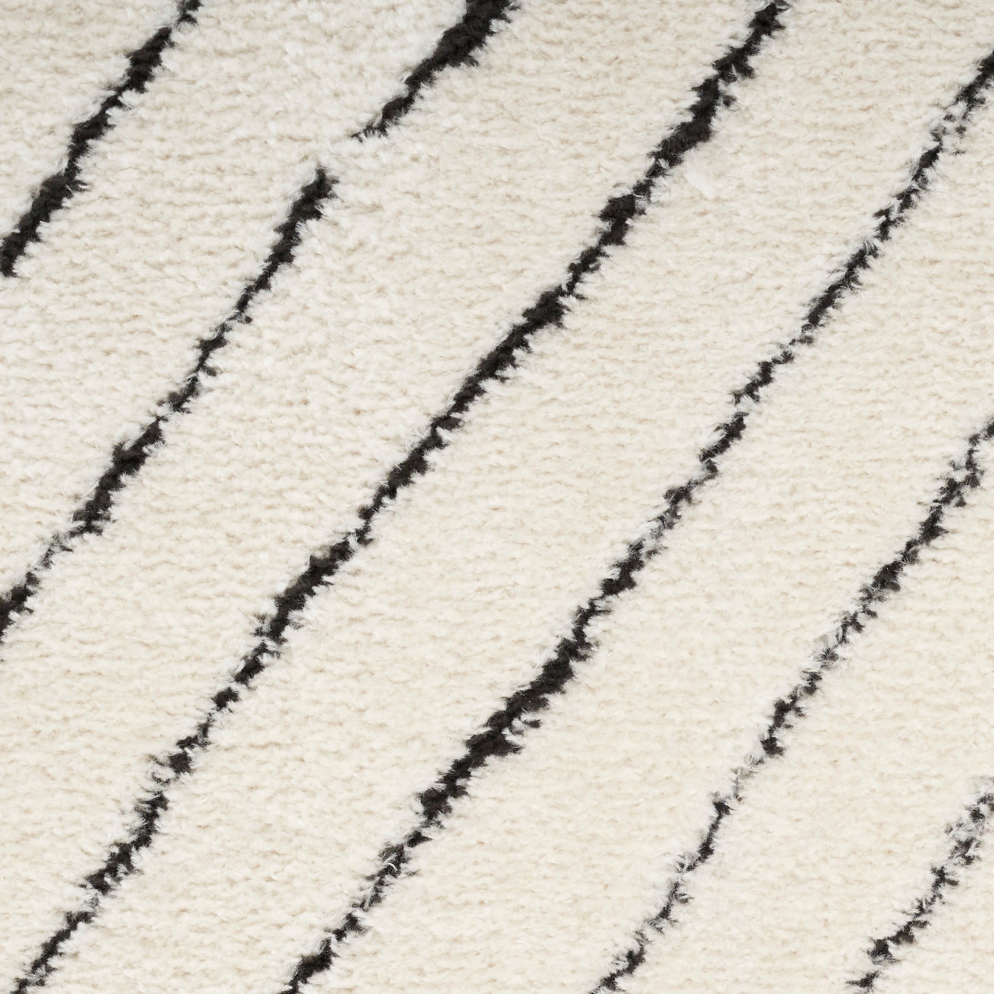 Cream plush carpet with bold black diagonal stripes, soft textured modern accent rug.