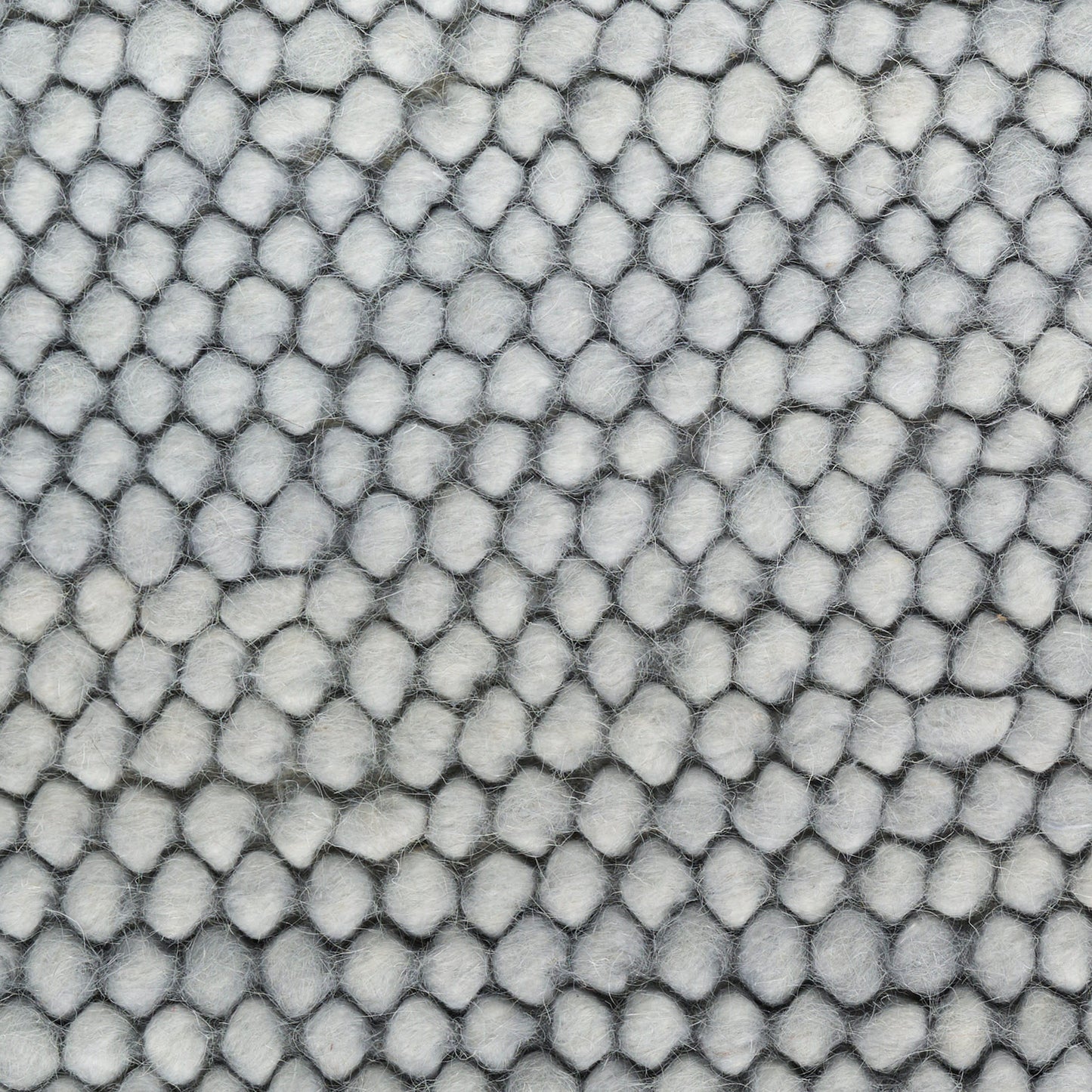 Close-up of light gray pebble-textured fabric with small rounded bumps; plush upholstery material.