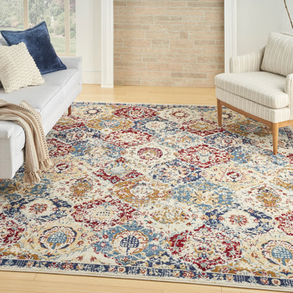 Living room with a colorful Persian-style rug in red, blue and cream; cream sofa with navy pillow and beige throw.
