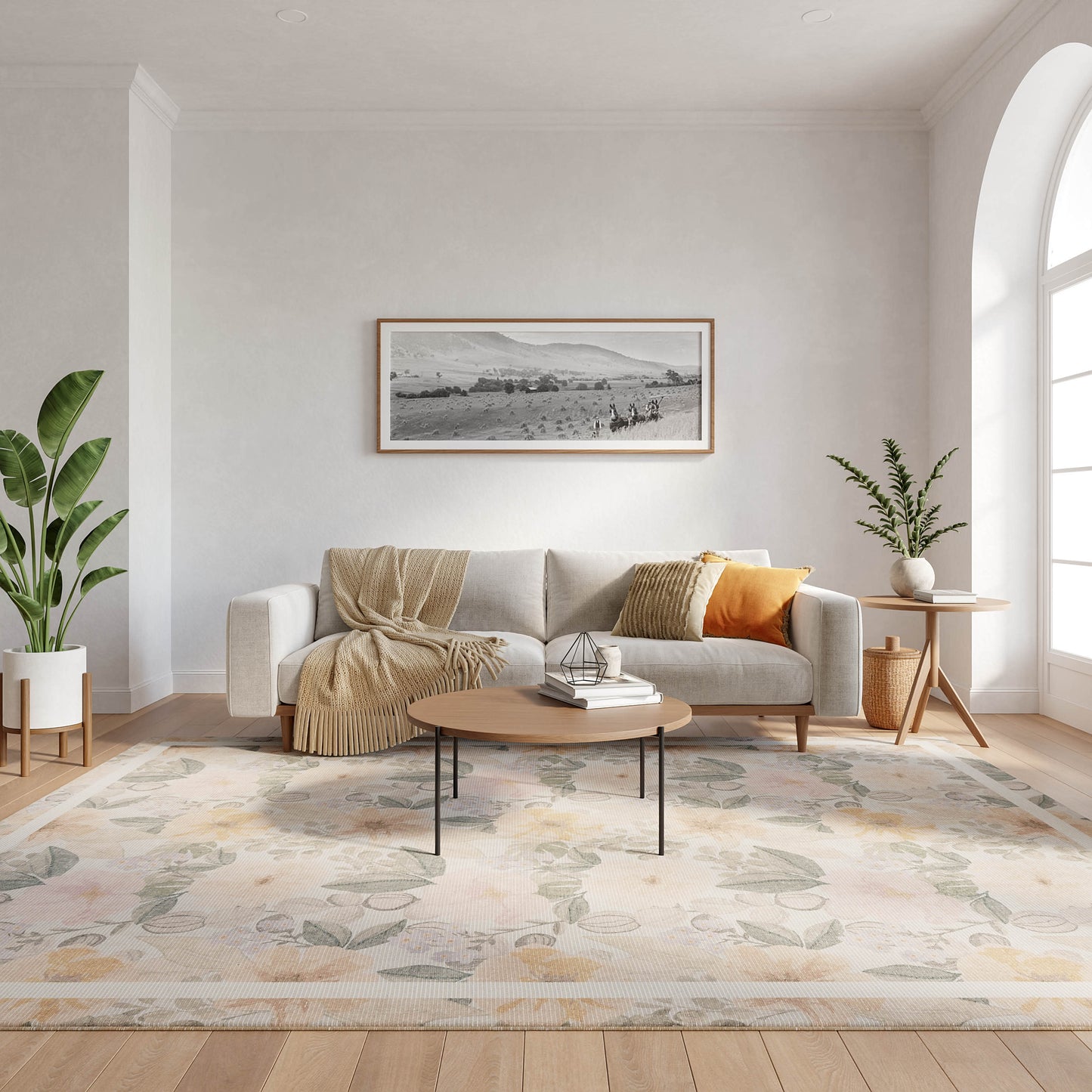 Bright living room with light gray sofa, beige throw, orange pillow, round wood coffee table, pastel floral rug, plants.