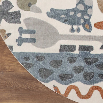 Circular soft rug with cream background and abstract blue, gray, and orange shapes; placed on wood floor.