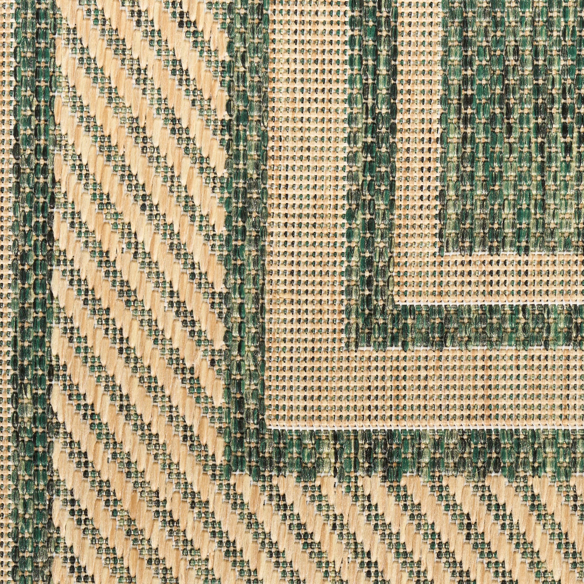 Close-up of woven beige and green geometric rug with nested rectangular borders and diagonal weave.