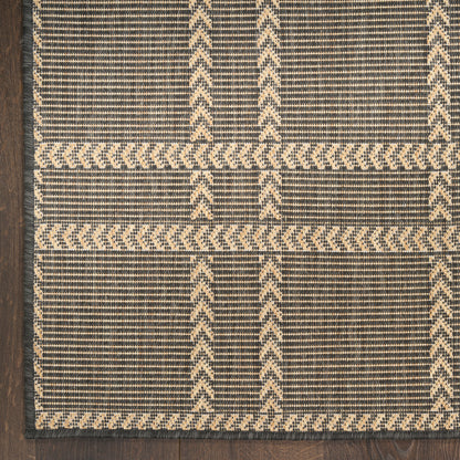 Dark navy woven rug with beige chevron grid and striped borders in a rustic geometric design.