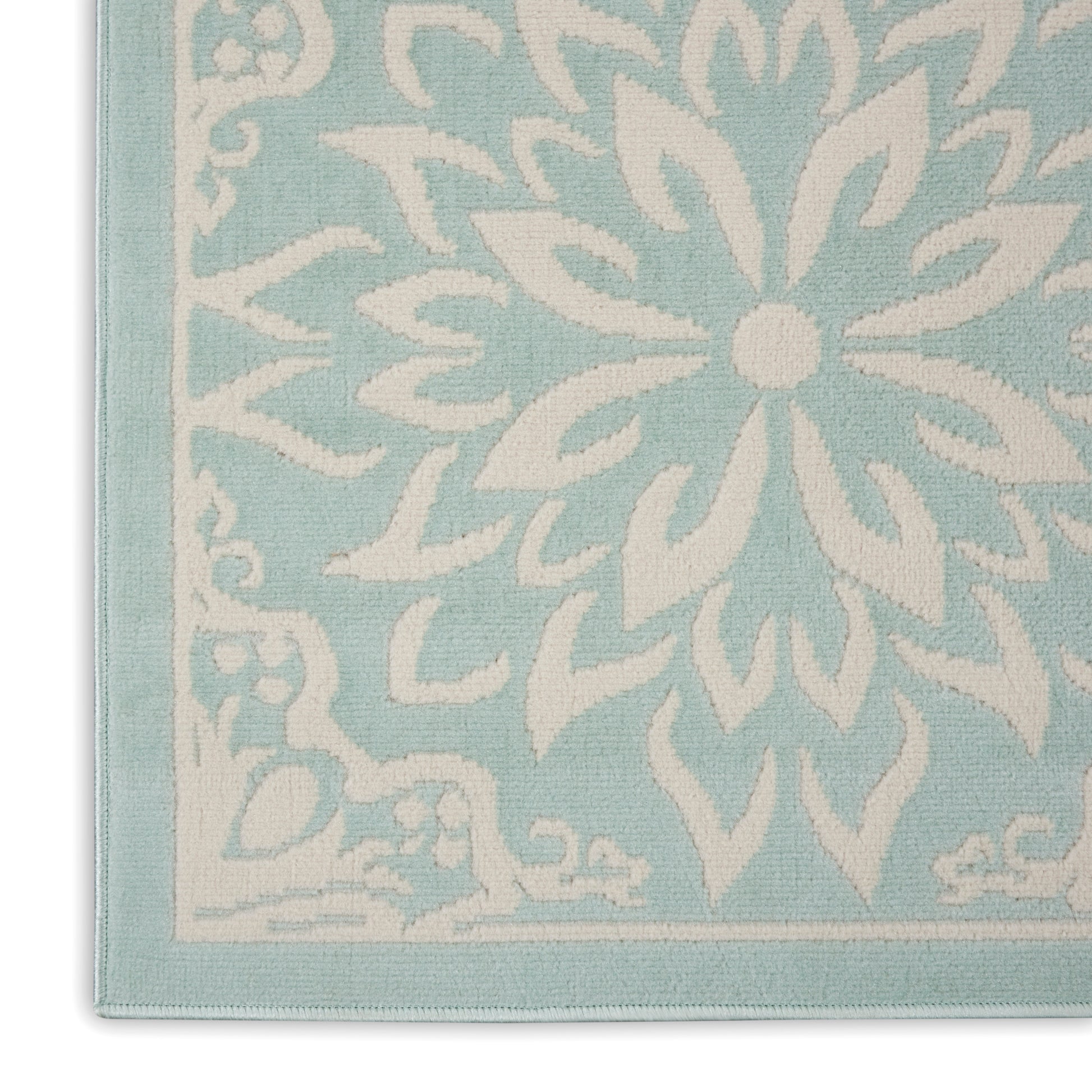 Light turquoise woven rug featuring a large white floral medallion and border; decorative area rug.