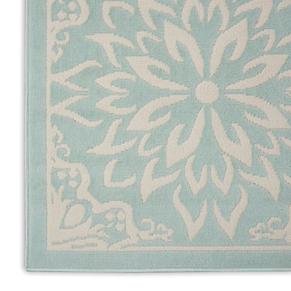 Light turquoise woven rug featuring a large white floral medallion and border; decorative area rug.