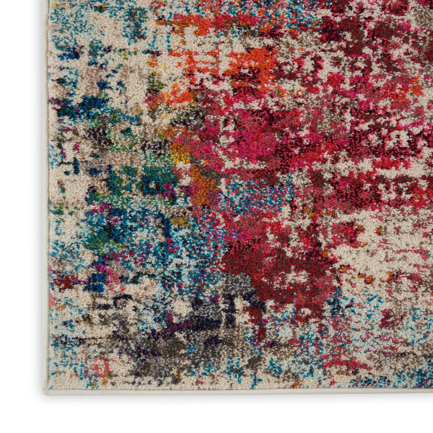 Close-up of a multicolor abstract rug with plush shag fibers in pinks, reds, blues, teals and beige.