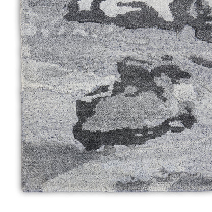 Gray shag rug with abstract rocky mountain pattern in light and dark gray tones.