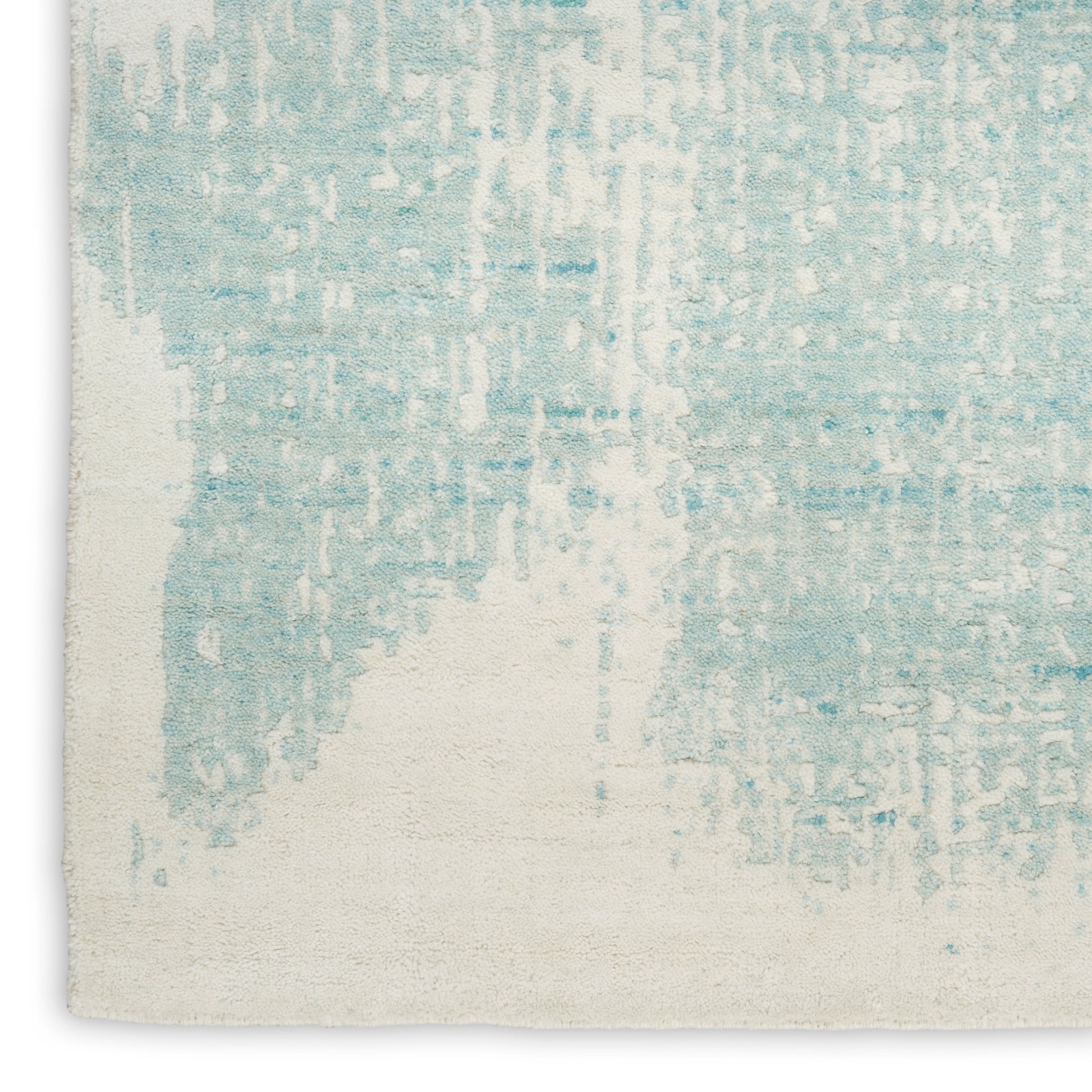 Soft blue abstract pattern rug on an off-white backdrop; contemporary rectangular woven rug for living room decor.