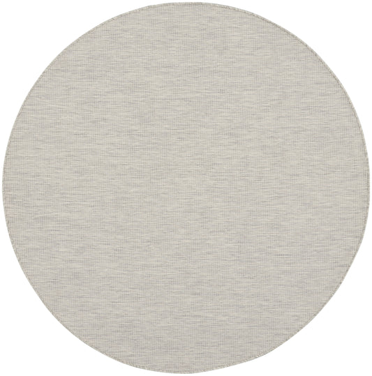 Beige circular rug with a subtle woven texture in soft neutral tones.